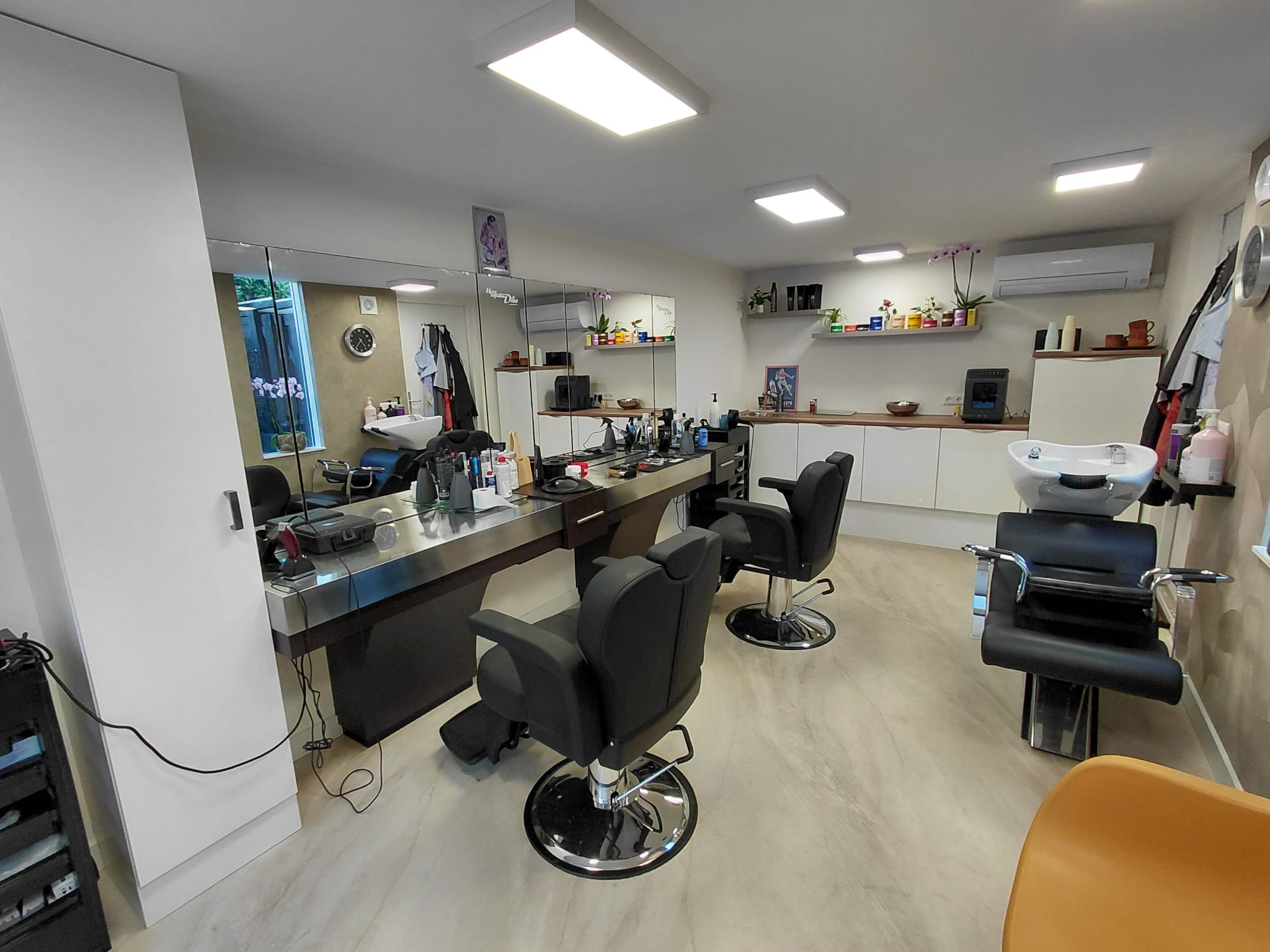 De lichte nieuwe Herenkapsalon Dilia met zwarte kappersstoelen en grote spiegels